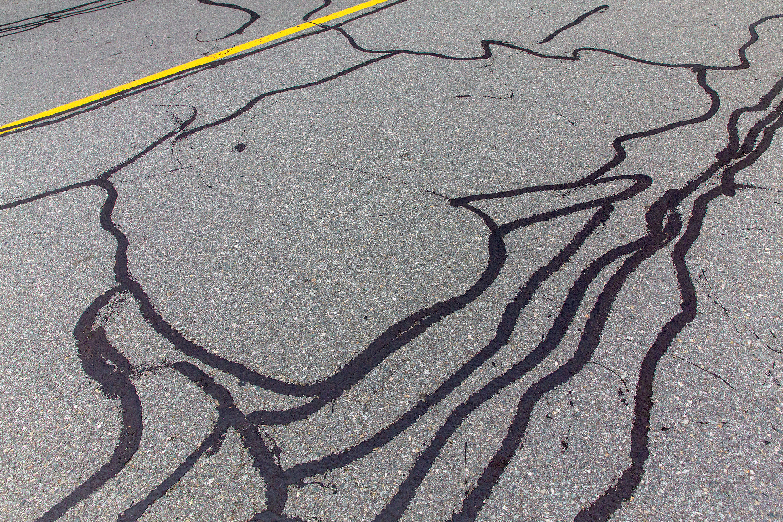 asphalt road with filled cracks. background of the fixed road